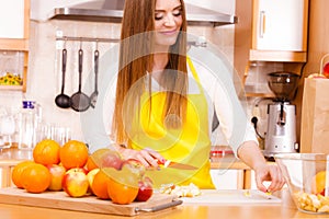 Woman housewife in kitchen cutting apple fruits