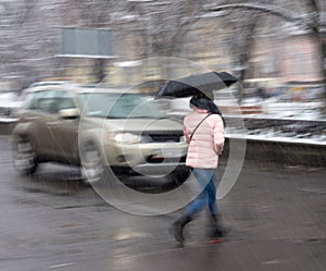 Woman on zebra crossing in a rainy day