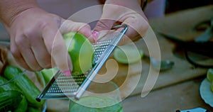 Woman zesting a lime over an iced cocktail