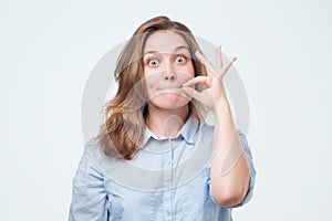 Woman zipping her mouth shut - keeping quiet concept