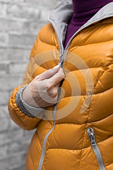 a woman zips up her jacket around her throat