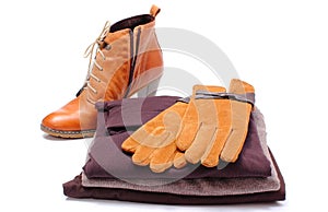 Womanly leather shoes, gloves and clothes on white background