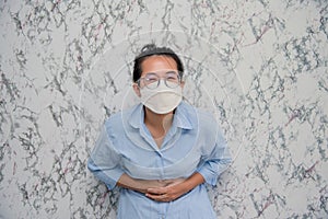 WomanMan puts on a face mask tummyache  on White background,pandemic and social distancing concept.Covid-19 photo