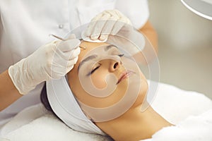 Womans face getting facial pores cleaning with special metal vidale needle from cosmetologist