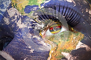 Womans face with planet Earth texture and ugandan flag inside the eye.