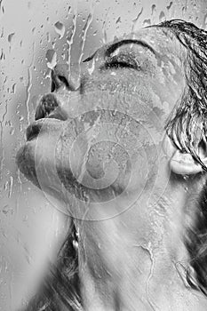 Womans face in the wet glass