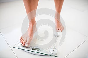 Womans feet going on weighting scale