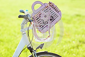 Womans hand bag in bicycle basket sloseup