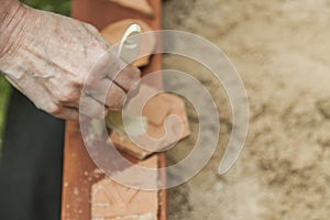 Womans hand cleaning with a brush, three pieces of pottery in a
