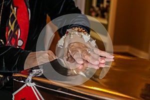 Womans hand with engagement ring opens big gold Christmas present - closeup and selective focus