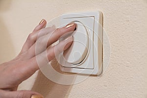 Womans hand with finger on light switch