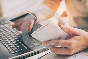 Womans hand holding credit card and smartphone