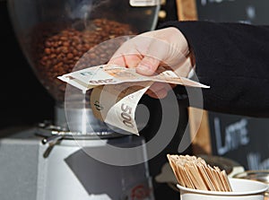 Womans hand paying for coffee with paper money