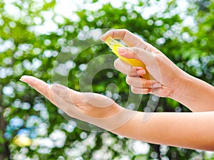 Womans hand pressing Alcohol Spray in the nature for clean her hand. Alcohol Spray is very important in daily life.