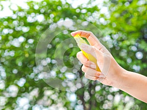 Womans hand pressing Alcohol Spray in the nature for clean her hand. Alcohol Spray is very important in daily life.