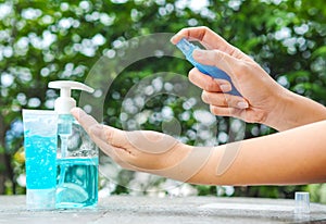 Womans hand pressing Alcohol Spray in the nature for clean her hand. Alcohol Spray is very important in daily life.