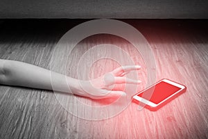 Womans hand reaches for mobile phone with red spot. Emergency concept