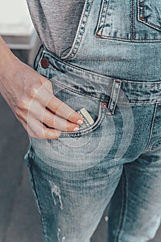 A womans hand takes out US dollar bills from her jeans pocket. The concept of finance, savings, financial expenses. Close-up.