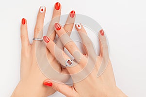 Womans hands with fashionable red manicure on white background. Summer nail design with heart