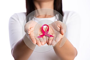 Womans hands holding pink breast cancer awareness ribbon on white background. healthcare and medicine concept