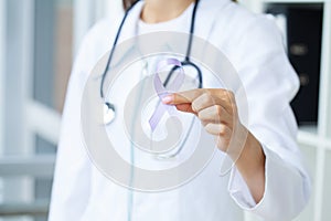 Womans hands holding purple domestic violence awareness ribbon