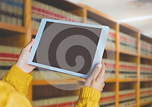 Womans hands holding tablet in Library