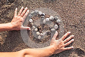 Womans hands making heart of marine shingles.