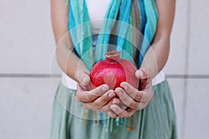 Womans hands with pomegranate