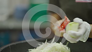 Womans hands shredding vegetables into strips at a market in bangkok