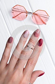 Womans hands with silver jewelry and accessories. Girl with minimal pink spring summer manicure design