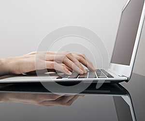 A womans hands type on a keyboard