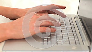 Womans hands typing on a computer