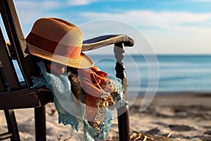 womans hat and gloves resting on a beach chair with the sea in the background