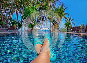 Womans legs lying down on a sunlounger looking over the water