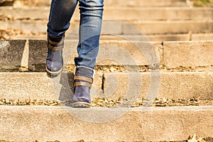 Womans legs in winter boots stepping downstairs