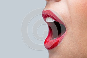 Womans mouth wide open with red lipstick.