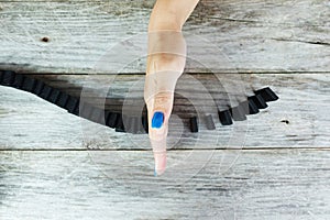 Womanâ€™s hand stopping domino effect on wooden table, aerial or top view