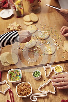 Womanâ€™s hands decorating cookies for Christmas
