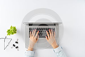 Womanâ€™s hands working on laptop on white background with business accessories. Elegant office desktop.