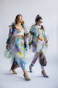 Women addicted of sales and clothes, wearing plastic, recycling concept