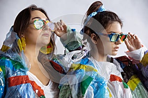 Women addicted of sales and clothes, wearing plastic, recycling concept