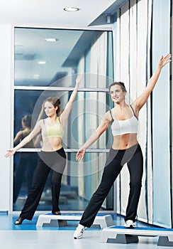 Women at aerobics exercise with fitness step board