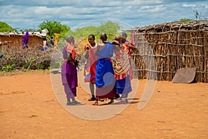 women from the African tribe Maasai in national dress in their village houses made of clay