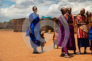 women from the African tribe Maasai in national dress in their village houses made of clay