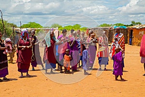 women from the African tribe Maasai in national dress in their village houses made of clay