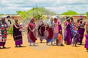 women from the African tribe Maasai in national dress in their village houses made of clay