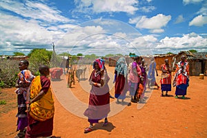 women from the African tribe Maasai in national dress in their village houses made of clay