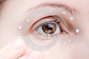 Women applying eye skin cream