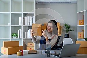 Women asian selling online at home with box. Selling online with box to accept order from customer. Live stream selling