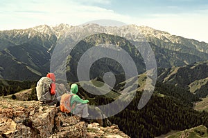 Women backpackers enjoy the view on mountain peak cliff